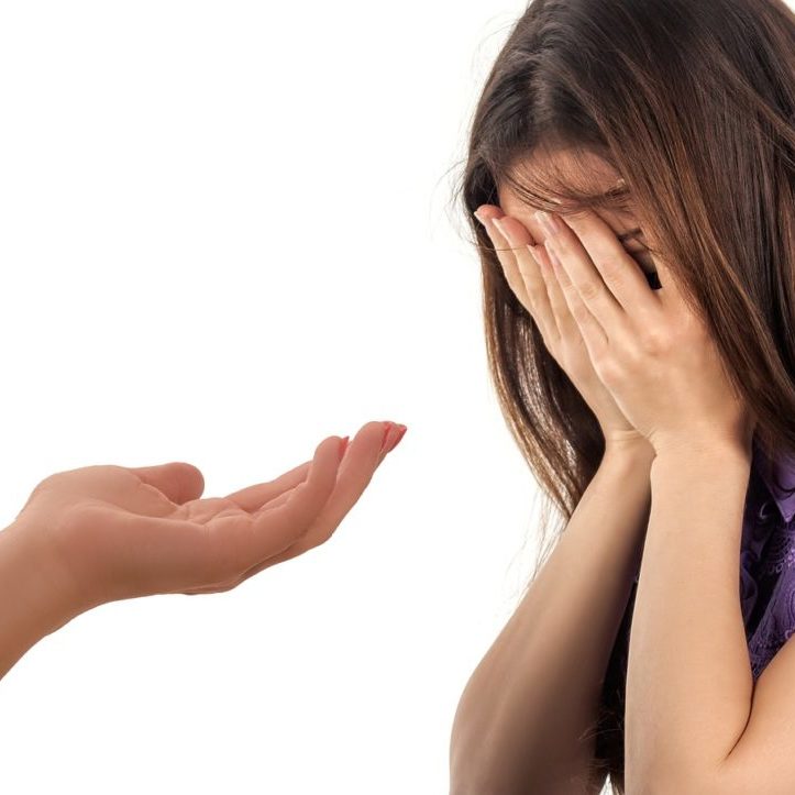 Une femme effrayée pleure, quelqu'un hors champ lui tend la main pour la soutenir
